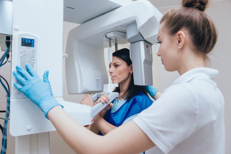 Young,Woman,Patient,Standing,In,X-ray,Machine.,Panoramic,Radiography